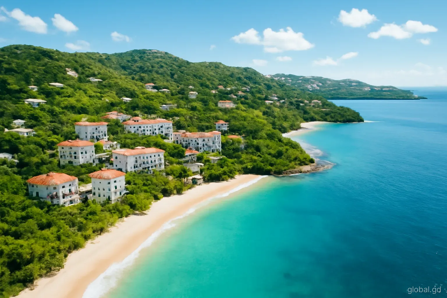 Aerial view of the Grand Anse and True Blue peninsula in Grenada, apartment buildings among green hills, turquoise bays and white beach curving away, late morning light